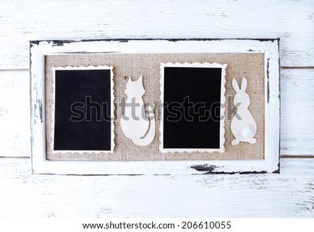 Wooden frames with blank old photo and paper animals on wooden background