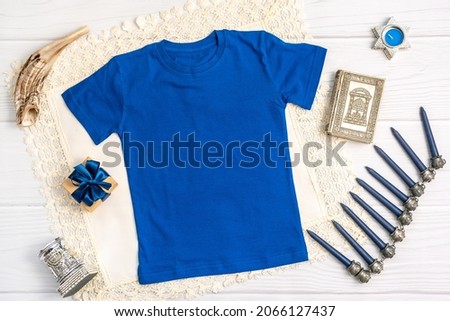 Jewish holiday Hanukkah blue t-shirt mock-up with menorah, gift box and candles, Top view from above. Flat lay, copy space.