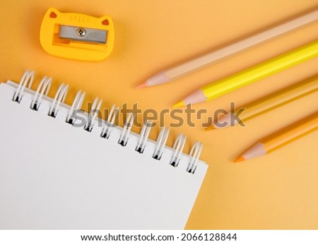 Yellow pencils, notepad and sharpener on a yellow background. Sketching, creativity, drawing