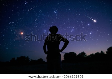 Silhouette of a man enjoying countryside under the starry skies. Royalty-Free Stock Photo #2066129801