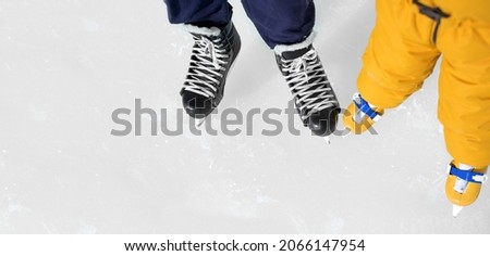 Father and daughter's skating shoes close-up on the background of an ice rink. Practice skating. Figure skating school-club. Banner with a place to copy. Winter sports