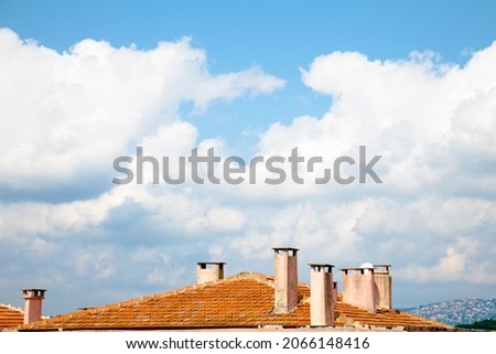 the roof, the roof under the white clouds, the chimneys and the tiles.