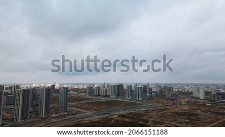 Construction of a modern city block Multi-storey buildings made of glass and concrete. Photographed in cloudy weather. Aerial photography.