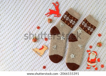 Woolen socks with a Christmas pattern, ornaments and decorations lie on a white background, new year holiday concept, gifts background