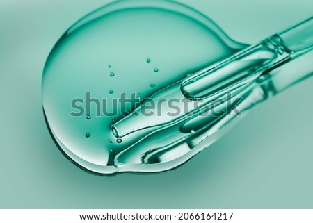 Liquid pipette oil or serum elixir cool emerald green on light green colored mirror background Royalty-Free Stock Photo #2066164217