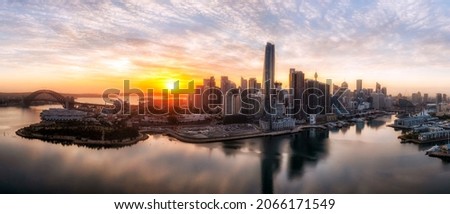Major Sydney city architecture landmark buildings on shores of Sydney harbour in aerial sunrise panorama.