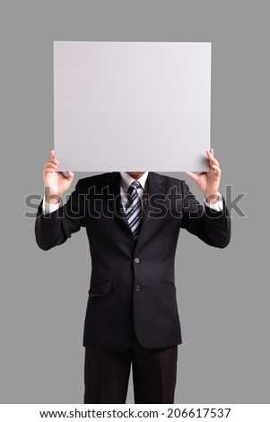 Young business man holding blank billboard card on his face with copy space isolated on gray background