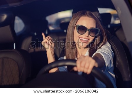 Photo portrait smiling woman wearing sunglass enjoying music driving car in summer Royalty-Free Stock Photo #2066186042