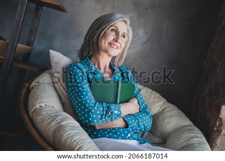 Photo of dreamy happy old attractive charming woman look away hug book smile indoors inside office workplace Royalty-Free Stock Photo #2066187014