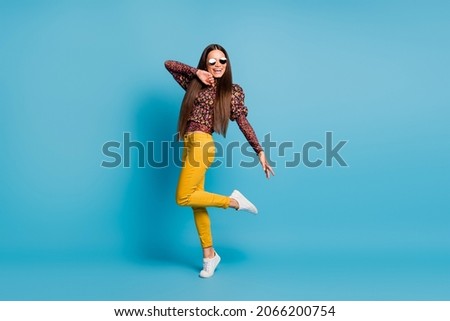 Full size photo of young beautiful cheerful good mood happy positive woman smile dance in sunglasses isolated on blue color background