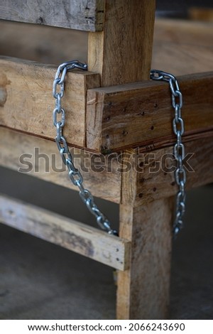 Two wooden tables attached to an iron chain to prevent theft.