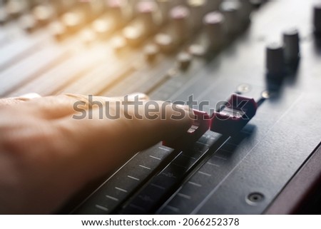 Entertainment industry. The person controls the regulator on the music console.