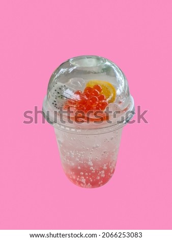 Sakura soda in a glass decorated with jelly, dragon fruit and oranges on a isolated white background. 