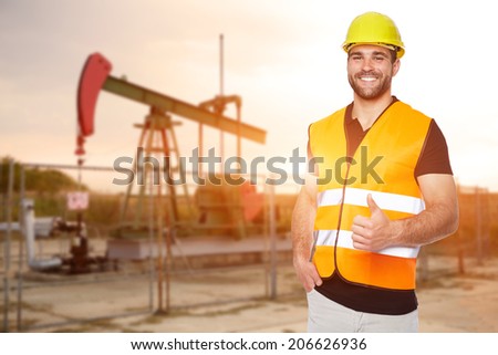 Refinery worker standing in front of the oil pump