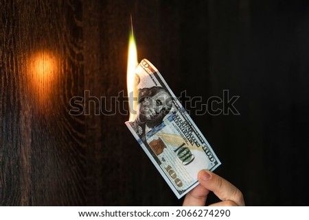 One Hundred Dollars are burning on a black background.