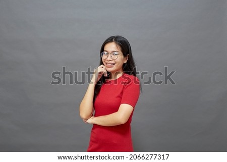 Portrait young asian woman brunette in a red dress cross arms on the chest and determined posed smiling confidently studio shot Isolated on gray background