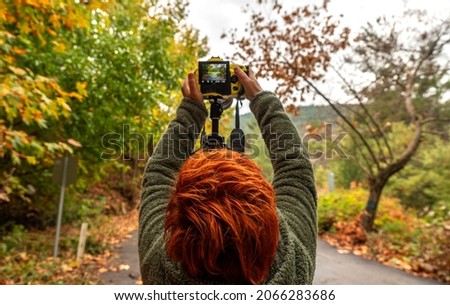 A photographer with his autumn-colored hair, taking to the road to photograph autumn colors