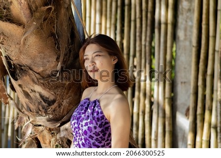 Asian woman with dress goes to the sea on the islands of Thailand on vacation with sandy beach and sea view.