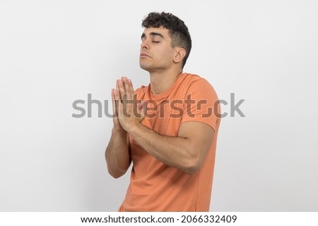 
a young boy praying on a white background.
