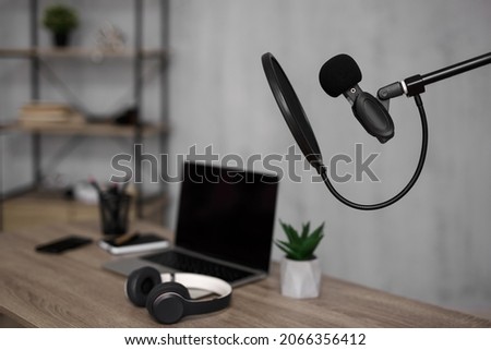 creativity, media content, podcast and blogging concept - workplace with laptop and microphone in home office