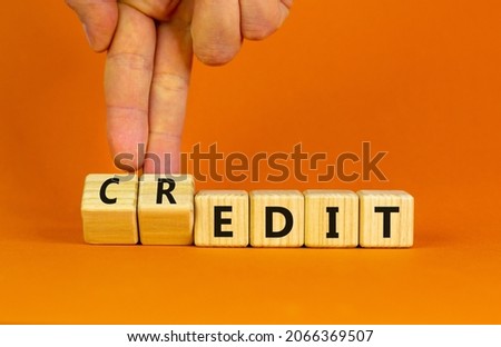 Credit to the edit symbol. Businessman turns wooden cubes and changes the word 'edit' to 'credit'. Beautiful orange background. Business, credit to the edit concept. Copy space.