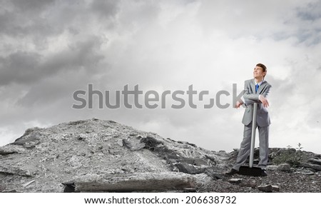 Young determined businessman with big hammer in hands