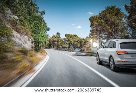 White car on a scenic road. Car on the road surrounded by a magnificent natural landscape. Royalty-Free Stock Photo #2066389745