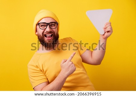 smiling man pointing at play button sign over yellow background, technology, media player button