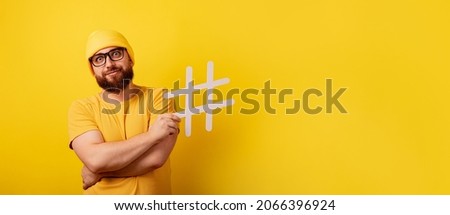 stylish bearded man with hashtag over yellow background, panoramic layout