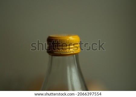 Yellow lid on a glass bottle. Glass water bottle. Dishes for liquid storage.