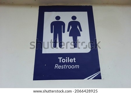 blue toilet or restroom sign in Indonesia with woman and man figure 