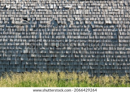 Weathered cedar shake shingles on the exterior of a building.