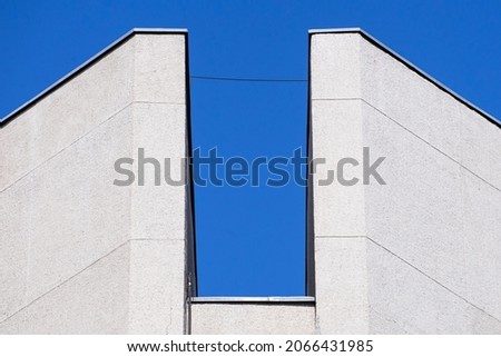 Abstract architectural detail of a concrete office building facade isolated with blue sky background