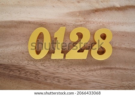 Golden Arabic numerals 0128 on a dark brown to white wood grain background.