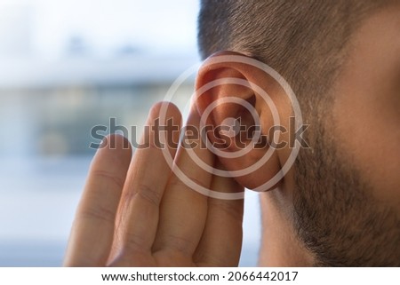 Tinnitus. Young man with hearing problems or hearing loss. Hearing test concept. Royalty-Free Stock Photo #2066442017