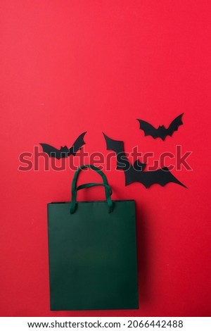 Halloween flat lay - bats and pumpkin on red background. gifts and shopping for halloween. place for text.holidays and surprises.
