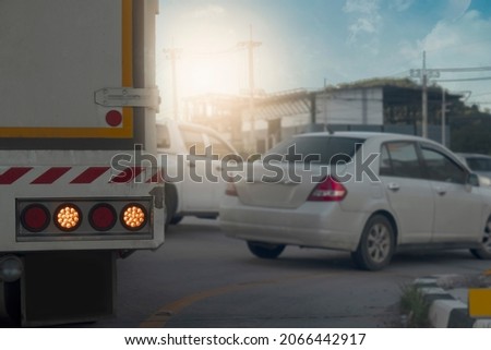 Rear side of cargo car with open turn light signal. with blurred of other cars for u-turn on the road on days.