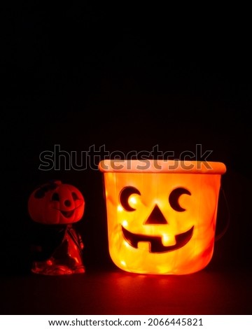 Two pumpkins can be seen in the dark.