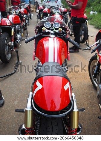 Close up pictures of a red motorbike that is prepared for track usage. 