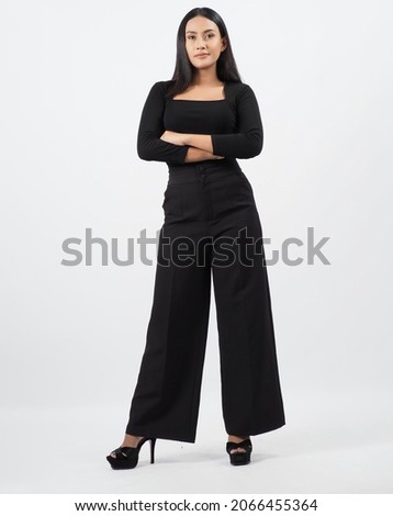 Asian woman full body. Thai woman in a modern chic style stands in white studio with elegant and confident pose. Casting model supporting actor actress. Asian woman fullbody pose in front of camera. Royalty-Free Stock Photo #2066455364