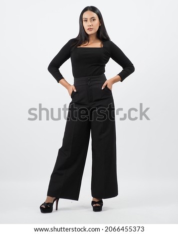Asian woman full body. Thai woman in a modern chic style stands in white studio with elegant and confident pose. Casting model supporting actor actress. Asian woman fullbody pose in front of camera. Royalty-Free Stock Photo #2066455373
