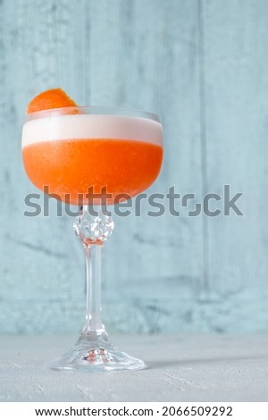 Glass of Ruby Cocktail garnished with grapefruit zest