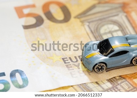 Toy cars with money. Euro cash with mini car. Concept image for rent car and automotive market. 
