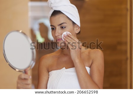 Woman cleaning face in bathroom  Royalty-Free Stock Photo #206652598