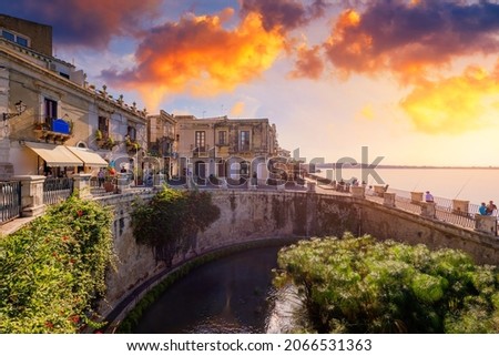 The Fountain of Arethusa and Siracusa (Syracuse) in a sunny summer day. Sicily, Italy. The Fountain of Arethusa in Ortygia, historical centre of Syracuse, Sicily, Italy. Royalty-Free Stock Photo #2066531363