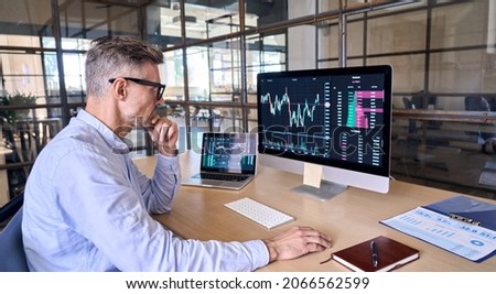 Mature crypto trader investor analyst broker using pc computer analyzing digital cryptocurrency exchange stock market trading graphs report thinking of investing funds risks doing global analysis. Royalty-Free Stock Photo #2066562599