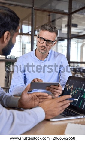 Two traders brokers stock exchange market investors discussing crypto trading chart using digital tablet and laptop analyzing financial risks and cryptocurrency growth forecasts for investment profit. Royalty-Free Stock Photo #2066562668