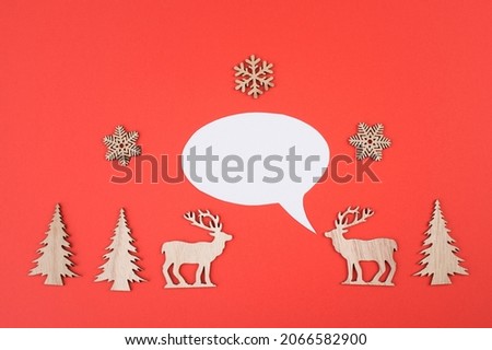 Two cute reindeers talking to each other, speech bubble with copy space, christmas greetings, red colored background