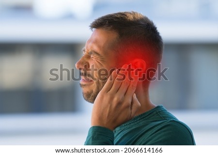 Man suffering from of strong earache or ear pain. Otitis Royalty-Free Stock Photo #2066614166