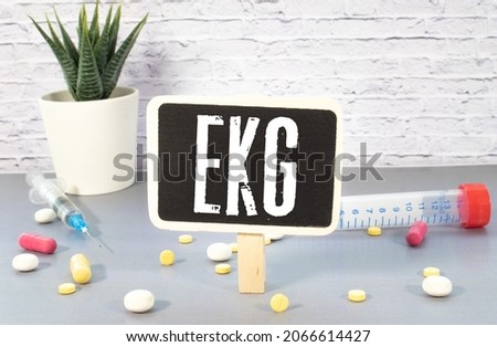 ECG Acronym or abbreviation to medical dignostics of electrocardiogram - cardiac test that measures electrical impulses in heart. Word ECG letters stands on printed strips of examples of EKG